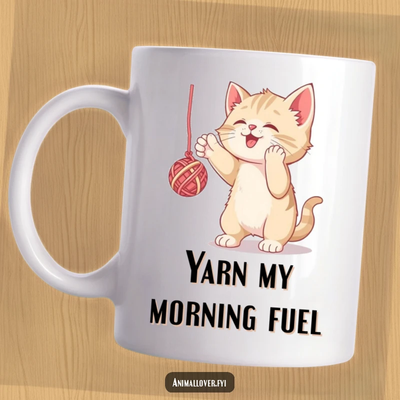 Funny mug showing a mischievous kitten gleefully batting at a dangling ball of yarn, capturing playful energy. A delightful present.