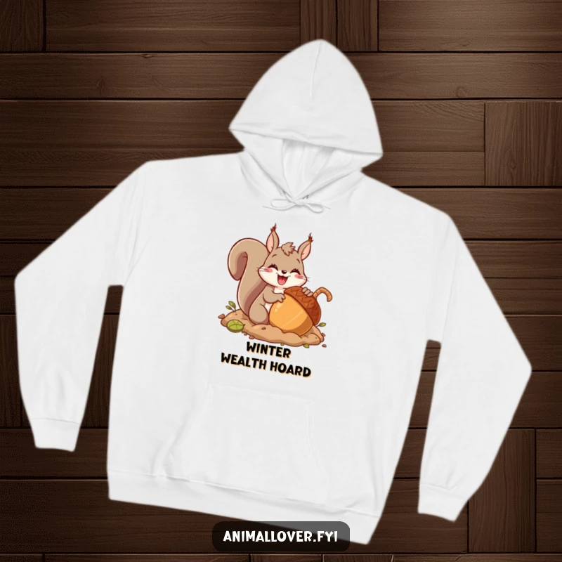 Funny hoodie showcasing an excited squirrel character burying a massive acorn with pure glee, celebrating winter preparation and abundance.